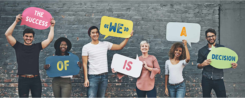 A diverse group holding up signs that spell out “The Success of We, is a Decision” celebrating team building values.